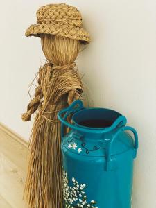 Un vaso blu con un cappello di paglia accanto a un secchio. di Farmer-Rabensteiner a Bad Gams
