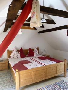 una camera da letto con un grande letto in legno con cuscini rossi di Farmer-Rabensteiner a Bad Gams