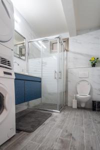 a bathroom with a toilet and a glass shower at PORT CITY HAIFA - Luxury Apartments 50 mtrs From The Beach in Haifa
