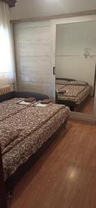 two beds sitting in a room with wooden floors at Kuća za odmor Ema in Vrnjačka Banja