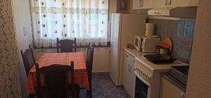 a small kitchen with a table and a microwave at Apartman "Kuća za odmor Ema" in Vrnjačka Banja