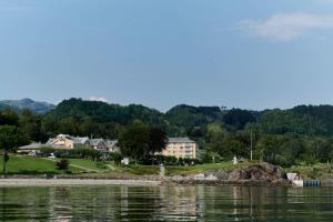 
a large body of water with houses and trees at Solstrand Hotel & Bad in Osøyro
