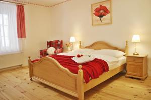 um quarto com uma cama grande e um cobertor vermelho em Apartmány Domestika em Český Krumlov