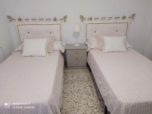 トレ・デル・マールにあるCasa Rosaのベッド2台が隣同士に設置された部屋です。