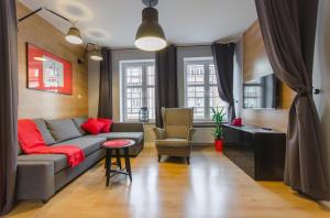 uma sala de estar com um sofá e uma cadeira em Grobla Old Town Apartment em Gdansk