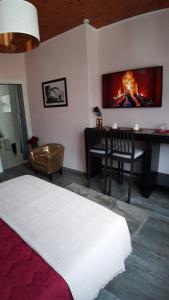 スパにあるRoom De Lux SPA " TABARKA "のベッドルーム1室(ベッド1台、テーブル、暖炉付)