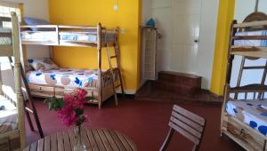 Cette chambre comprend des lits superposés et une table ornée d'un vase de fleurs. dans l'établissement Germaican Hostel, à Port Antonio