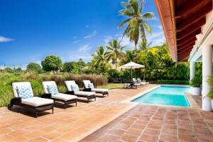 a patio with chairs and a swimming pool at Los Lagos 19- Golf and Lake View 5-Bedroom Villa in La Romana