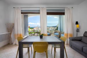 a living room with a table and chairs and a couch at Le Maree Apartments in Cannigione