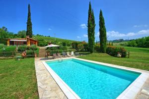 a swimming pool in a yard with trees and a house at Holiday Home Casa Ovile by PosarelliVillas in Certaldo