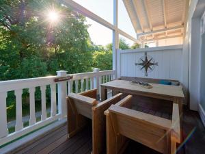 a porch with a wooden table and benches on a balcony at Dünenpark Binz - WG 40 "Strandgut" in Binz