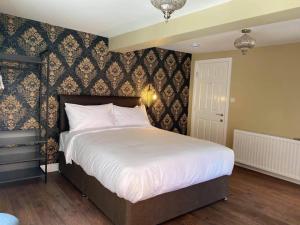 1 dormitorio con 1 cama blanca grande y pared en The Black Swan Hotel, en Scarborough
