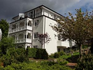 ein weißes Gebäude mit einem Balkon darauf in der Unterkunft Villa Sanddorn in Binz
