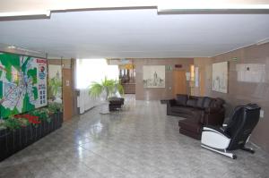 a lobby with couches and chairs in a building at Hotel Słupsk in Słupsk