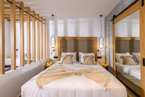 a bedroom with two beds and two mirrors at Stella Palace Aqua Park Resort in Hersonissos