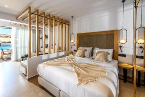 a bedroom with a large white bed with a wooden headboard at Stella Palace Aqua Park Resort in Hersonissos