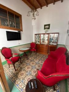 a living room with red chairs and a tv at Casa Celestino in Santa Cruz de la Palma