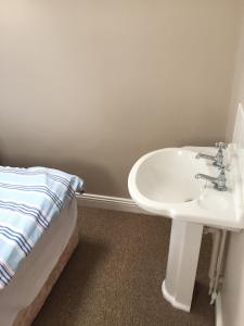 Detached two bedroom cottage في Riverchapel: حمام مع حوض وسرير