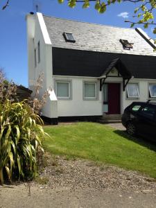 a house with a car parked in front of it at Detached two bedroom cottage in Riverchapel