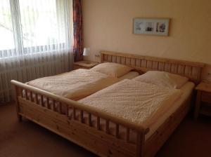 a bedroom with a large wooden bed with two pillows at Landgasthof zum Wiesengrund in Hünfeld