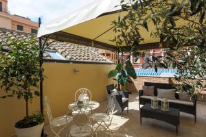 patio con tavolo e sedie sotto ombrellone di Wonderful Apartment in the City Centre - Big Terrace & WiFi a Cagliari