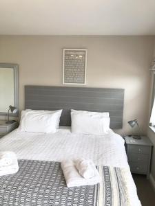 a bedroom with a large bed with two towels on it at The Stables self catering in Seahouses