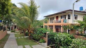a building with a palm tree in front of it at Felicitas Tagaytay in Tagaytay