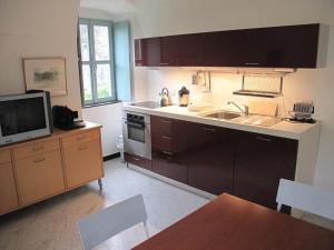a kitchen with a sink and a tv in it at Oliveto Sleeps 4 with Private Garden in Castelbianco