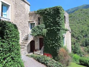 un bâtiment recouvert de lierre avec un banc devant lui dans l'établissement Oliveto medieval setting, à Castelbianco