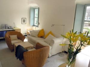 Oliveto medieval setting في Castelbianco: غرفة معيشة مع أريكة بيضاء وكراسي