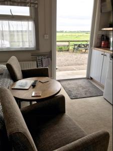 a living room with a table and chairs and a view of the beach at The Stables self catering in Seahouses