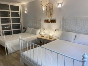 a bedroom with two white beds and a staircase at AlquilaEasy Windsor in Benalmádena