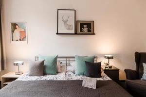 a bedroom with a bed with blue and grey pillows at Sommers Hotel Altes Posteck in Reichenbach im Vogtland