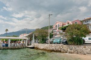 a group of buildings and cars parked next to a body of water at Apartments Milanović in Herceg-Novi