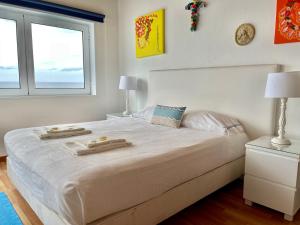 a white bedroom with a large bed with two trays on it at Casa do Mar in São Roque