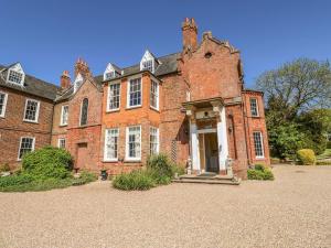 un antiguo edificio de ladrillo rojo con una puerta blanca en Gainsford Hall en Spilsby