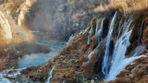 een schilderij van een waterval naast een rivier bij Apartman Black River in Plitvička Jezera