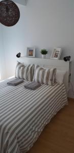 a bedroom with a bed with striped sheets and pillows at La Casita Blanca in El Astillero