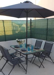 a table with two chairs and an umbrella at La Casita Blanca in El Astillero