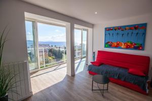 ein Wohnzimmer mit einem roten Sofa und einem großen Fenster in der Unterkunft Très beau T2 climatisé refait à neuf, vue mer panoramique exceptionnelle à 120m à pied de la plage in La Ciotat
