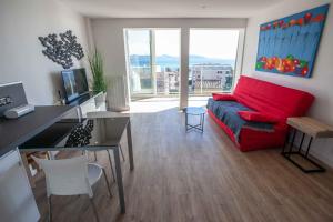 a living room with a red couch and a table at Très beau T2 climatisé refait à neuf, vue mer panoramique exceptionnelle à 120m à pied de la plage in La Ciotat