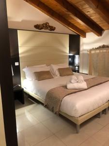 a bedroom with a large bed with two towels at Villa Giotto Luxury Suite & Apartments in Mestre