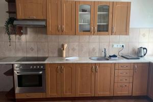 a kitchen with wooden cabinets and a sink at Vaivari Retreat in Jūrmala