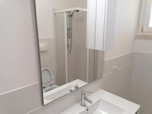 a bathroom mirror with a sink and a toilet at appartamento martina in Scarlino