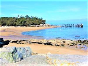 una playa de arena con un muelle en el agua en 3 Bed - Sleeps 6 - Air-Con - Free Parking, en Saint-Jean-de-Monts