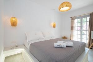 a bedroom with a white bed and white walls at Kasteli Luxury Rooms in Perissa