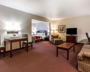 Quality Inn & Suites Fort Madison near Hwy 61 في Fort Madison: فندق غرفه بسرير وصاله