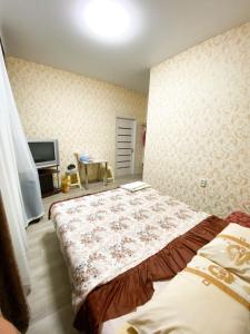 1 dormitorio con 1 cama y TV. en Посуточная аренда жилья, en Mohyliv-Podilʼsʼkyy