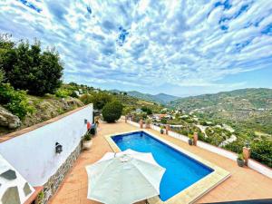 una piscina con 2 sombrillas en un patio en Villa La Posada, en Canillas de Albaida