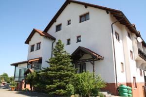 a white building with a tree in front of it at Hotel Waldschlösschen in Dankmarshausen